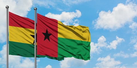 Ghana and Guinea Bissau flag waving in the wind against white cloudy blue sky together. Diplomacy...
