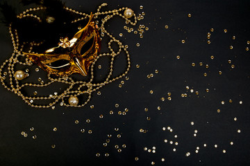 Black and gold carnival mask. Top view image of masquerade background. Flat lay. Mardi Gras...