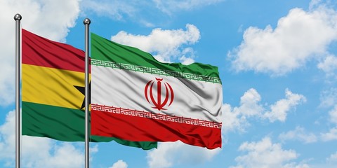 Ghana and Iran flag waving in the wind against white cloudy blue sky together. Diplomacy concept, international relations.