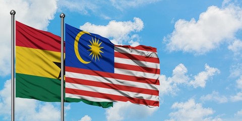 Ghana and Malaysia flag waving in the wind against white cloudy blue sky together. Diplomacy concept, international relations.
