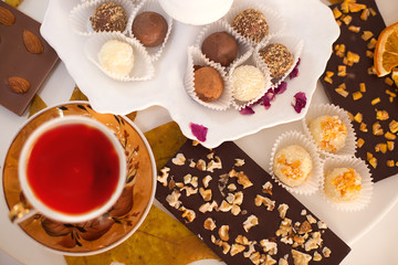 a Cup of tea on the table with desserts. an abundance of sweets and delicious handmade sweets. celebration and tea party. The view from the top, Flatley. chocolate with nuts and marzipans