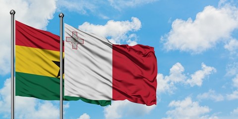 Ghana and Malta flag waving in the wind against white cloudy blue sky together. Diplomacy concept, international relations.