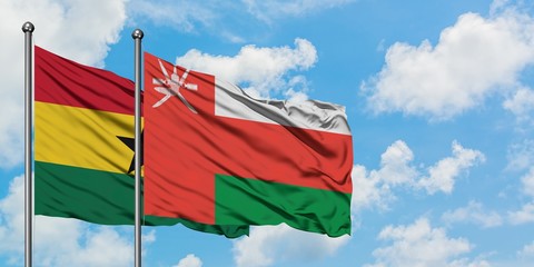 Ghana and Oman flag waving in the wind against white cloudy blue sky together. Diplomacy concept, international relations.