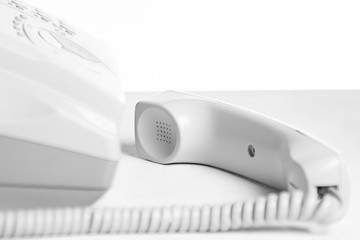 Landline telephone handset on a white table. Communication concept
