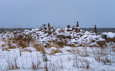 zen towers of flat stones on the shore of a winter lake