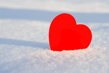 Fototapeta premium Red paper heart on a snowdrift close up, with place for your text.