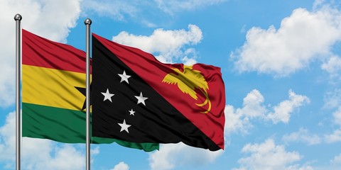 Ghana and Papua New Guinea flag waving in the wind against white cloudy blue sky together. Diplomacy concept, international relations.