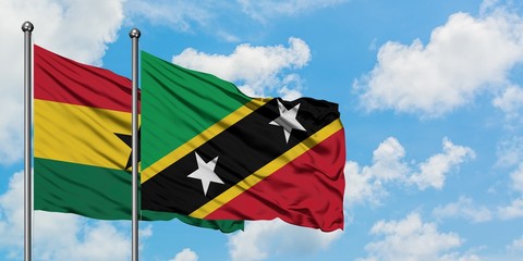 Ghana and Saint Kitts And Nevis flag waving in the wind against white cloudy blue sky together. Diplomacy concept, international relations.