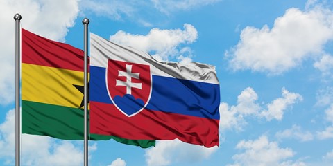 Ghana and Slovakia flag waving in the wind against white cloudy blue sky together. Diplomacy...