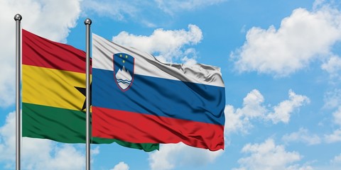 Ghana and Slovenia flag waving in the wind against white cloudy blue sky together. Diplomacy concept, international relations.