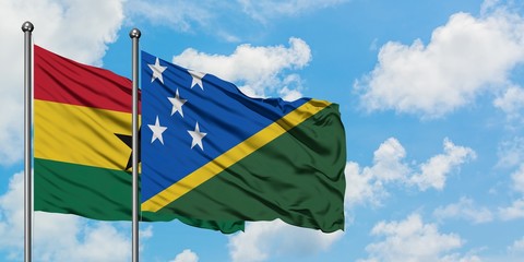 Ghana and Solomon Islands flag waving in the wind against white cloudy blue sky together. Diplomacy concept, international relations.