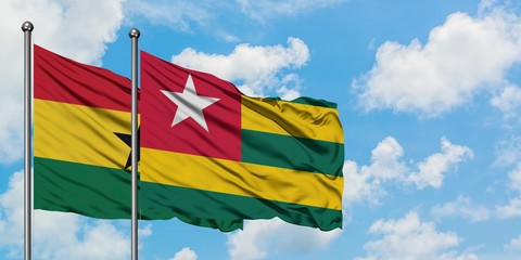 Ghana and Togo flag waving in the wind against white cloudy blue sky together. Diplomacy concept, international relations.