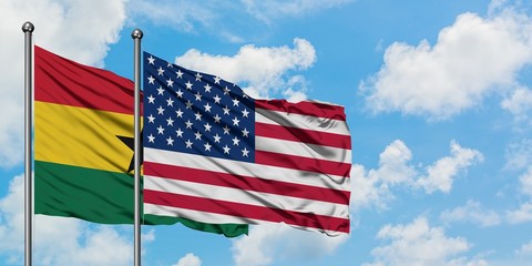 Ghana and United States flag waving in the wind against white cloudy blue sky together. Diplomacy concept, international relations.