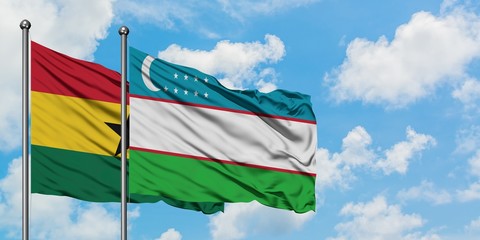 Ghana and Uzbekistan flag waving in the wind against white cloudy blue sky together. Diplomacy concept, international relations.