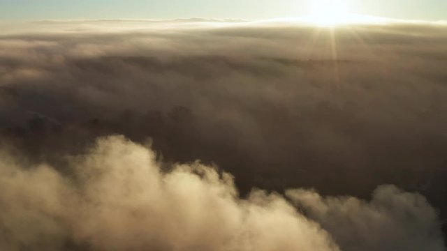 Coastal town in Latvia under thick fog during sunrise - aerial drone shot