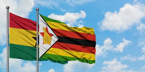 Ghana and Zimbabwe flag waving in the wind against white cloudy blue sky together. Diplomacy...