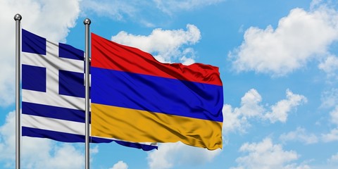 Greece and Armenia flag waving in the wind against white cloudy blue sky together. Diplomacy concept, international relations.