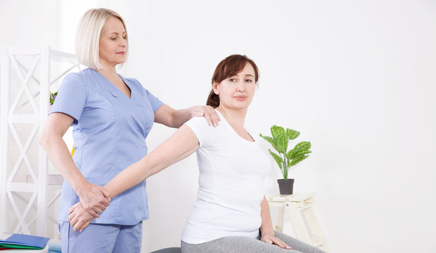 Physiotherapist working with middle aged patient in clinic