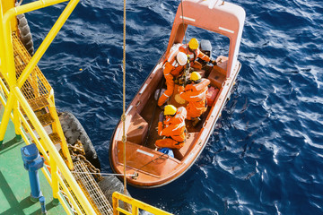 Fast rescue craft being deployed from a construction barge at oil field