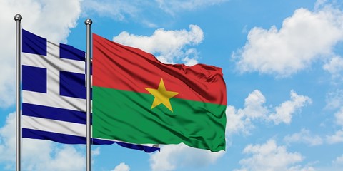 Greece and Burkina Faso flag waving in the wind against white cloudy blue sky together. Diplomacy concept, international relations.