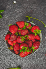 Ripe red strawberries on black table, Strawberries in white bowl. Fresh strawberries. grey strawberries. Diet food. Healthy, vegan. Top view. Flat lay. Copy space.