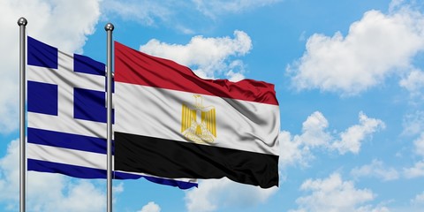Greece and Egypt flag waving in the wind against white cloudy blue sky together. Diplomacy concept, international relations.
