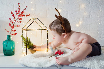cute baby boy with red nose and funny reindeer horns