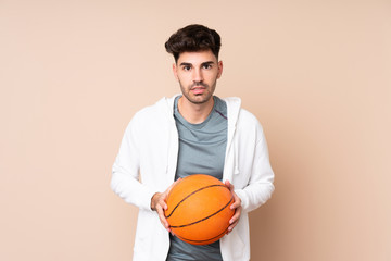 Young man over isolated background playing basketball