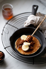 Pancakes with banana, walnuts and honey. Morning concept