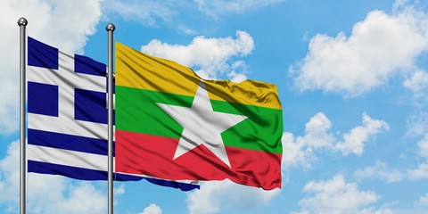 Greece and Myanmar flag waving in the wind against white cloudy blue sky together. Diplomacy concept, international relations.