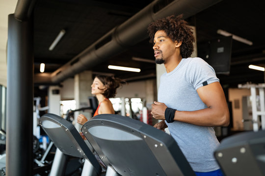Fit group of people exercising on a treadmill in gym