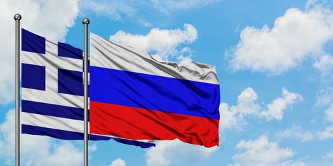 Greece and Russia flag waving in the wind against white cloudy blue sky together. Diplomacy...