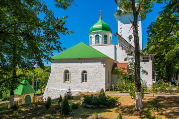 Fototapeta premium Orthodox Church with green domes and white walls. Monastery