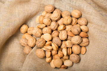 Autumn still life with nuts and almonds on brown background