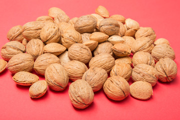 Still life with nuts and almonds on red background