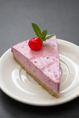 Cheesecake slice with berries, pink cheesecake isolated on dark background, dessert or breakfast. Sweet food.