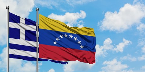 Greece and Venezuela flag waving in the wind against white cloudy blue sky together. Diplomacy concept, international relations.