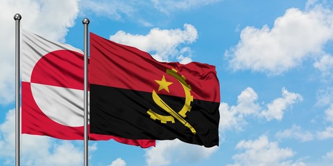 Greenland and Angola flag waving in the wind against white cloudy blue sky together. Diplomacy...