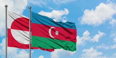 Greenland and Azerbaijan flag waving in the wind against white cloudy blue sky together. Diplomacy...