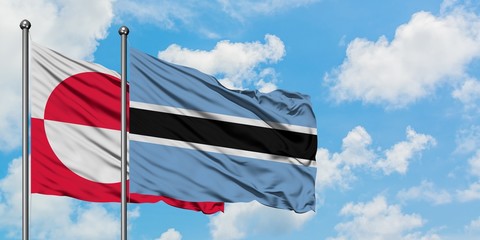 Greenland and Botswana flag waving in the wind against white cloudy blue sky together. Diplomacy concept, international relations.