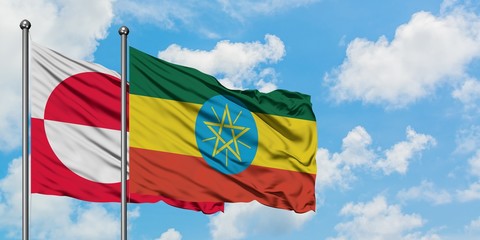 Greenland and Ethiopia flag waving in the wind against white cloudy blue sky together. Diplomacy concept, international relations.