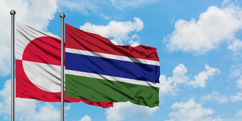 Greenland and Gambia flag waving in the wind against white cloudy blue sky together. Diplomacy concept, international relations.