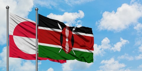 Greenland and Kenya flag waving in the wind against white cloudy blue sky together. Diplomacy...