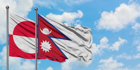 Greenland and Nepal flag waving in the wind against white cloudy blue sky together. Diplomacy concept, international relations.
