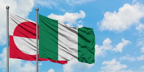 Greenland and Nigeria flag waving in the wind against white cloudy blue sky together. Diplomacy concept, international relations.