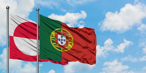 Greenland and Portugal flag waving in the wind against white cloudy blue sky together. Diplomacy concept, international relations.