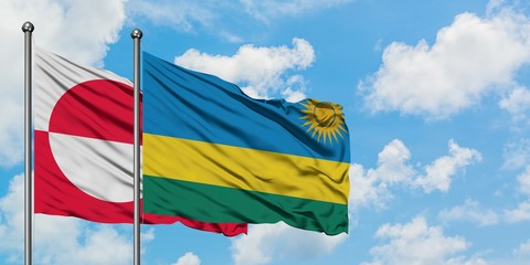 Greenland and Rwanda flag waving in the wind against white cloudy blue sky together. Diplomacy concept, international relations.