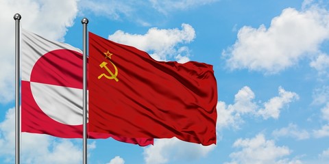Greenland and Soviet Union flag waving in the wind against white cloudy blue sky together. Diplomacy concept, international relations.