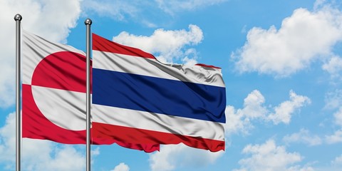 Greenland and Thailand flag waving in the wind against white cloudy blue sky together. Diplomacy concept, international relations.