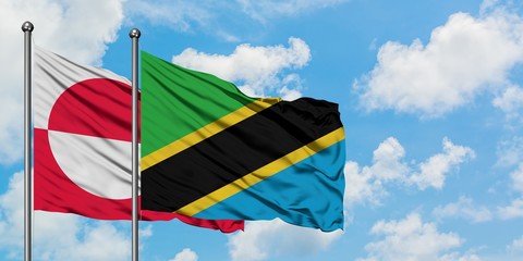 Greenland and Tanzania flag waving in the wind against white cloudy blue sky together. Diplomacy concept, international relations.